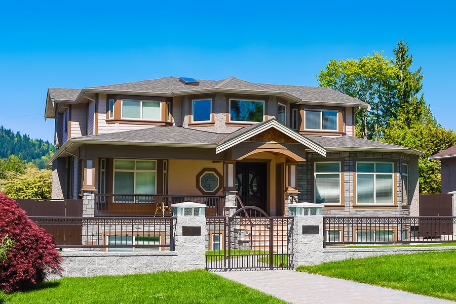 Luxury residential house with iron fence and green lawn in front Luxury residential house with iron fence and green lawn in front